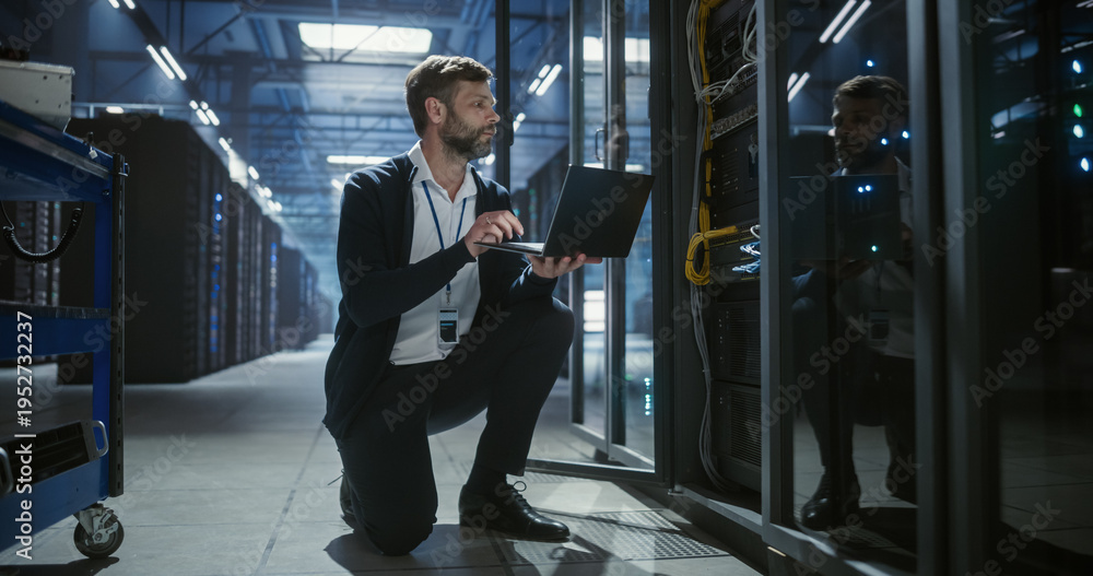 Fototapeta premium Technician uses a laptop of server rack systems in a data center, analysis of device connections, network cables, electronics for secure business infrastructure, it service, and software operation.