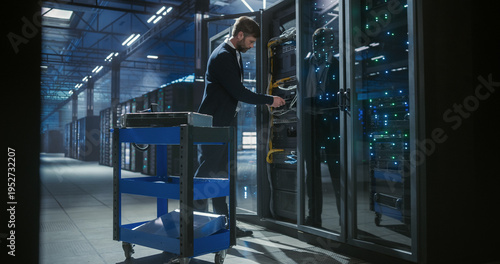 Foto Technician in a data center inspects network hardware among rows of servers, equ