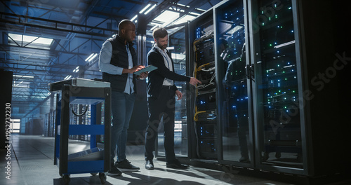 Billede på lærred Technicians inspect and maintain server racks in a modern data center, using a tablet to monitor equipment, check connections,  operation of network hardware, mainframe, server racks