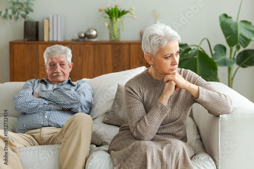 Marriage crisis relationship problems. Old couple quarreling. Sad mature disappointed woman sitting away from husband after having quarrel. Senior couple not talking having problems in relationship