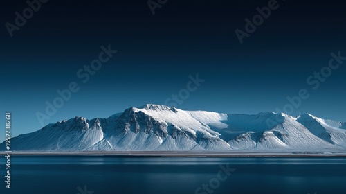 Snow covered mountains with clear dark blue sky, large mountain range in distance creating an arctic Icelandic landscape scenery