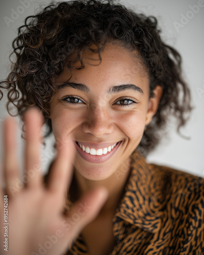 Wallpaper Mural Cheerful young woman with a warm gesture: A close-up portrait showcases a radiant woman with a wide smile and outstretched hand, conveying friendliness and positivity. Torontodigital.ca
