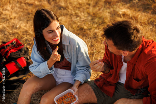 Foto Couple having healthy snack while taking a hiking break