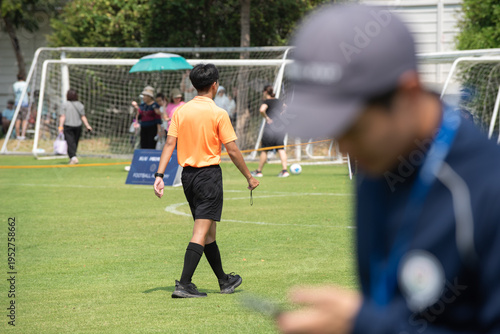 Professional soccer referee officiating a girls' youth football match with intensity and passion on the pitch.