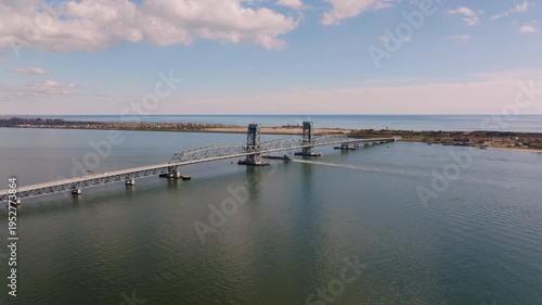 Wallpaper Mural Aerial drone view of Marine Parkway Bridge spanning calm coastal water with surrounding shoreline and breakwater under a soft cloudy sky. Torontodigital.ca