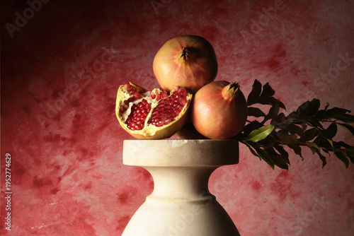Melagrane su piedistallo in marmo con sfondo artistico rosso: spazio per il testo