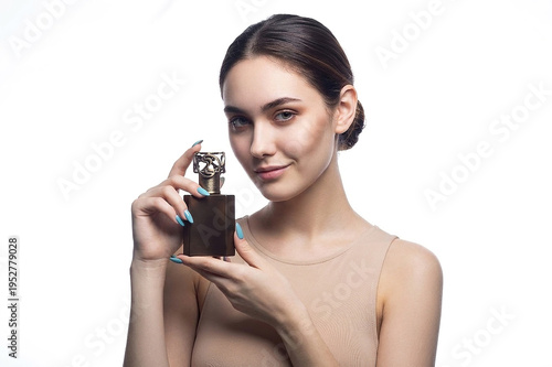 A beautiful sexy lady in an elegant nude bodysuit holds a bottle in her hands. Fashion beauty portrait of fashion model