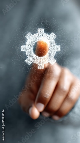Hand holding gear with light close up of a hand grasping a gear with a bright white light emanating from its center