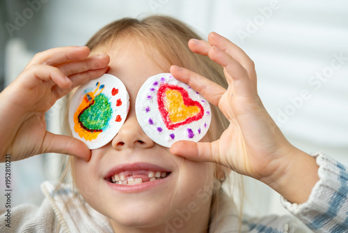 Funny toothless girl covering eyes with snail and heart, joyful child artist, draw on fluffy sponge painting paper, Childhood creativity 3D textured canvas art paper painting, preschooler imagination