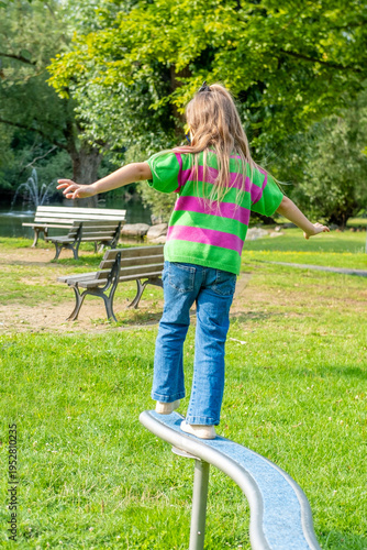 Photography Child walking balance beam in park, Little girl balancing outdoor equipment, gre