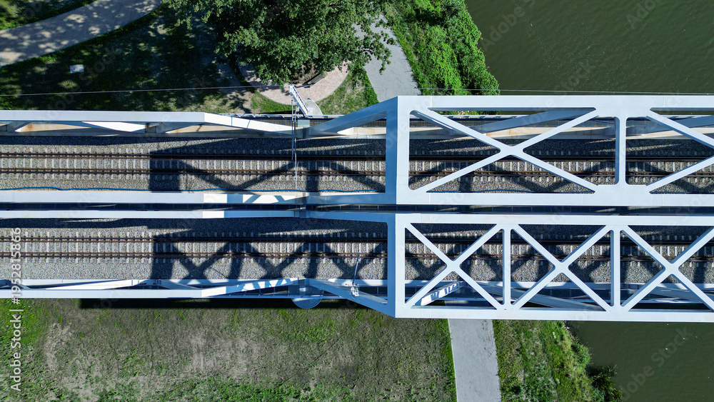 Fototapeta premium A modern iron railway bridge on a sunny day, seen from above