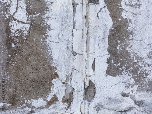The texture of a cracked concrete house wall. Rough concrete surface. Close-up.