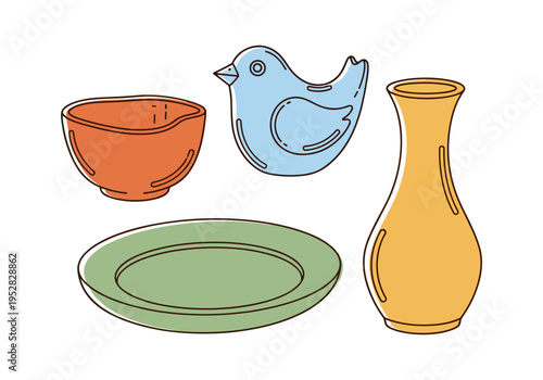 Set of colorful ceramic tableware and decorative bird figurine on white background