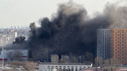 Large fire with thick black smoke over city buildings urban disaster emergency situation