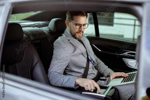 Businessman works on laptop...