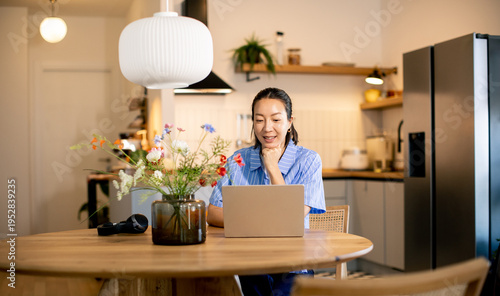 Woman sits at table working...
