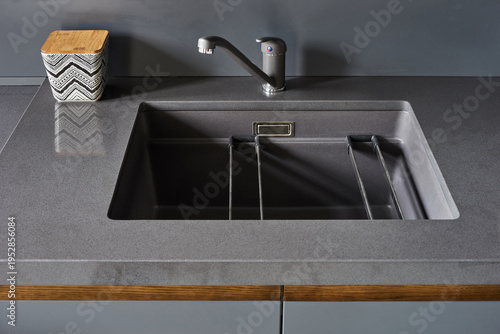 The modern graphite-colored kitchen with
stone countertops and wooden doors is served with vegetables, fruits and bread