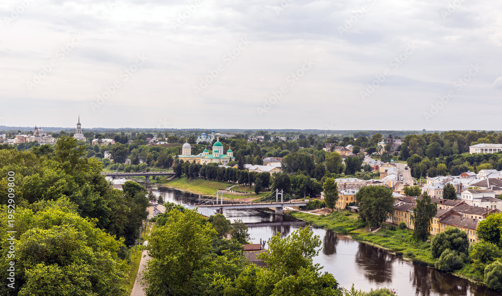 Fototapeta premium Idyllic aerial city view of Torzhok, Russia showcasing lush greenery, calm river, and distinct historical architecture in a serene atmosphere