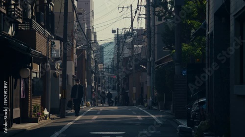 Low angle view of Kyoto neighborhood street with dense wiring and traditional architecture.