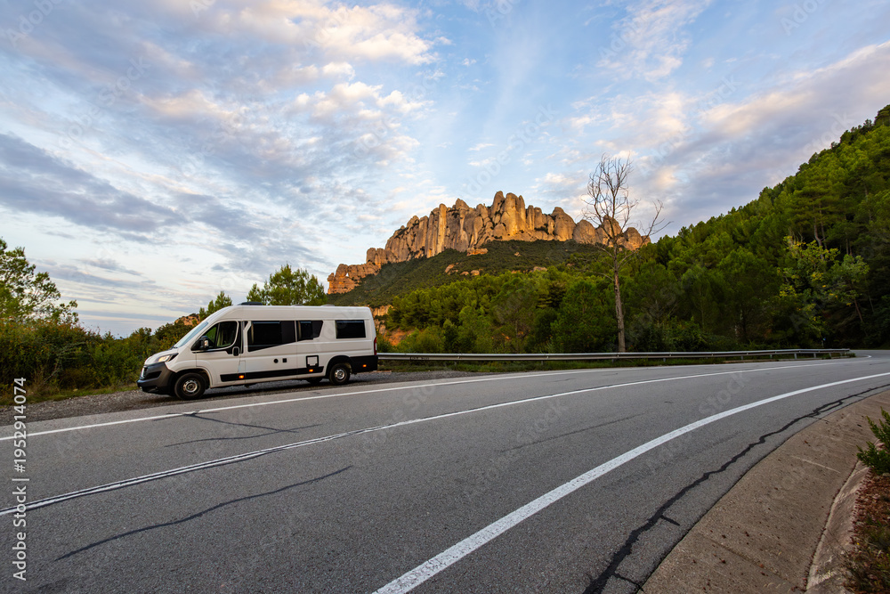 Fototapeta premium Campervan parked on road traveling through Montserrat mountains