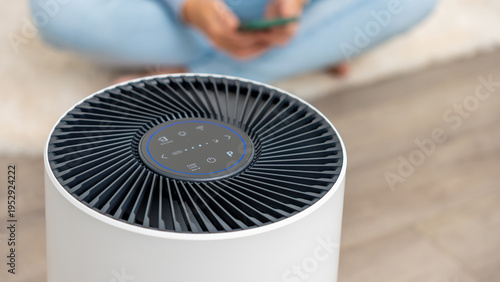 Modern air filter device with sleek design and control panel, enhancing indoor air quality in a cozy living space with copy space