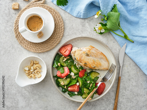 Healthy lunch with grilled chicken, salad, and coffee served on a table with decorative items and fresh greens