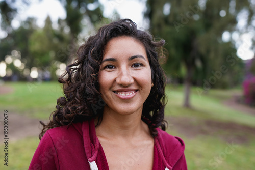Portrait of native american woman smiling in front of  camera with park in background - Indigenous girl outdoor