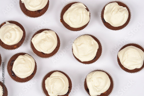 Fotografia A flat lay perspective of several dark cocoa muffins topped with smooth white bu