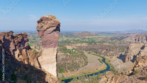 Deep river canyon view with a hiking trail alongside massive vertical rock walls at Smith Rock State Park, Oregon, USA