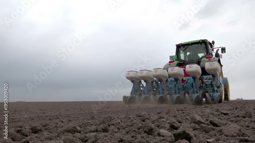 Modern Agriculture – Tractor Sowing Sugar Beet on Farmland; Tractor with seeder sowing sugar beet on agricultural land