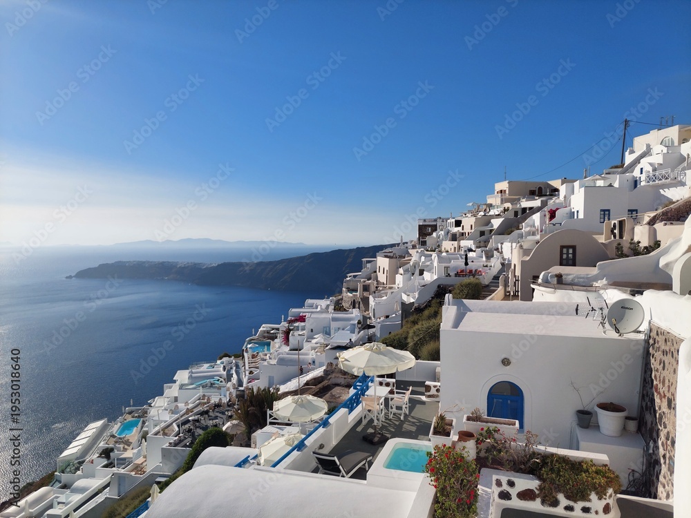 Fototapeta premium Whitewashed houses with terraces and pools and a beautiful view in Imerovigli on Santorini island, Greece