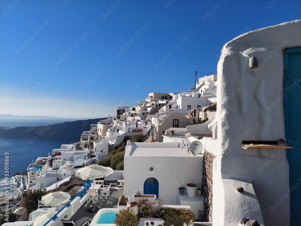 Fototapeta premium Whitewashed houses with terraces and pools and a beautiful view in Imerovigli on Santorini island, Greece