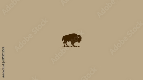 A silhouette of a large bovine animal on grass against a neutral textured background