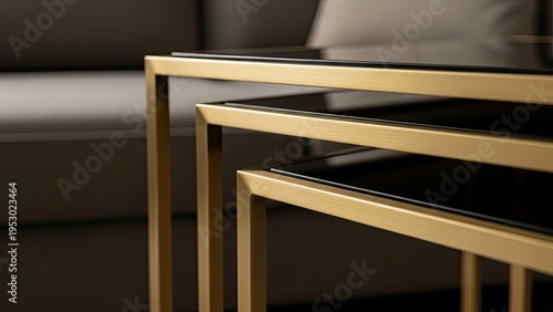 Stacked, gold-framed nesting tables with glass tops, set against neutral-toned sofa