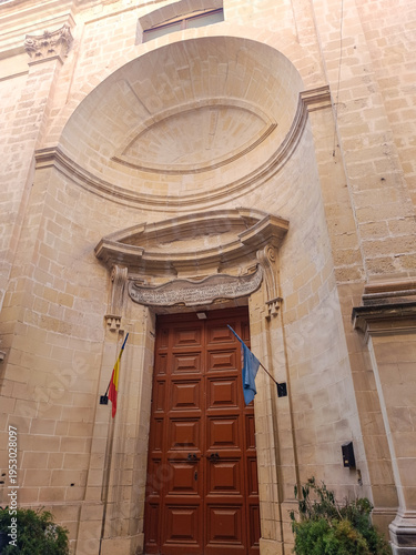 Facade and closed door of Church of St Roque  (Romanian Orthodox Church) with flags, Valletta MALTA