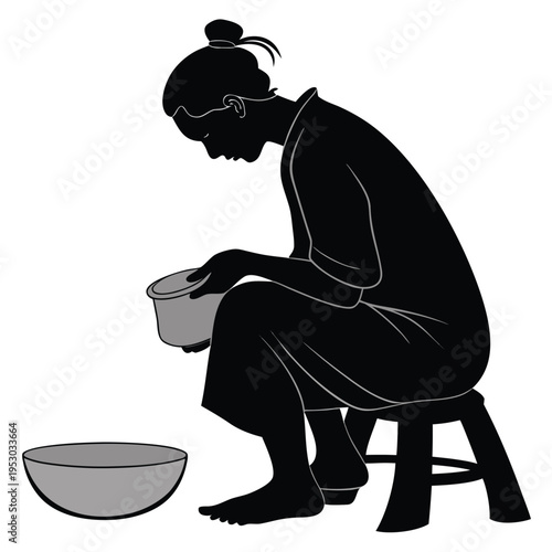Silhouette of a person sitting on a stool washing something in a bowl, depicting daily chores or hygiene