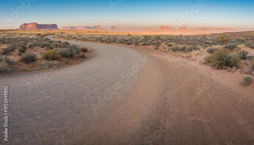 A winding dirt and gravel road creates a captivating copy space in a desert landscape.