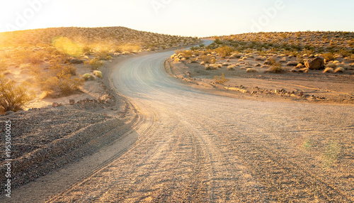 A winding dirt and gravel road creates a captivating copy space in a desert landscape.