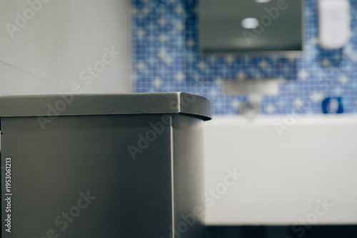 Tableau sur toile Modern bathroom with gray trash bin and blue mosaic tile wall, clean and minimal