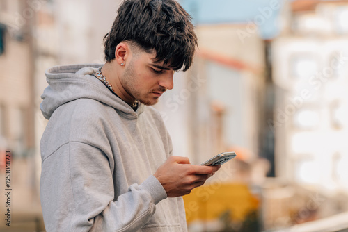 Foto portrait of a young man with a mobile phone on the street