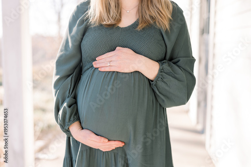 Fotografie A pregnant woman cradles her belly
