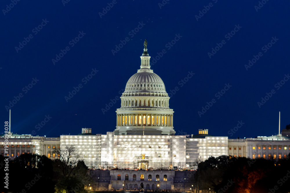 Fototapeta premium The United States Capitol with scaffolding at night
