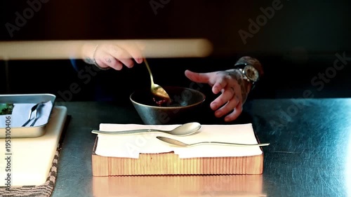 Chef preparing raw beef dish. Focused chef carefully assembling raw beef with precise movements