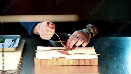 Detailed slowmotion shot of chef arranging exquisite sauce on sophisticated plate at counter