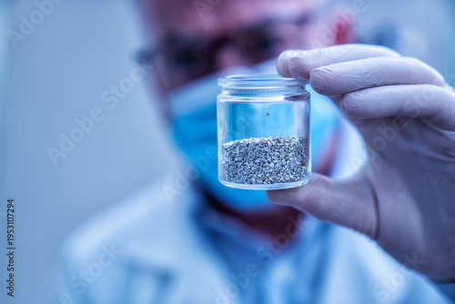 Canvas Print Scientist in lab holding glass vial containing granular rare earth elements