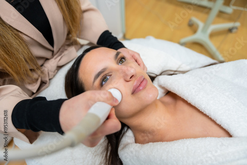 Fotografie Woman receiving radio frequency beauty treatment in aesthetic clinic