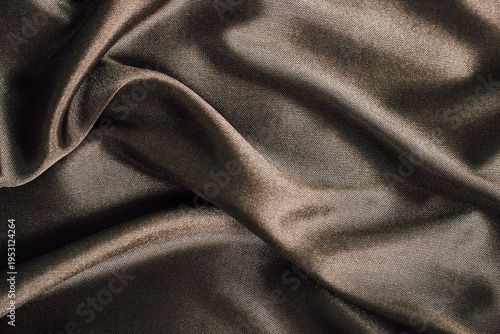 Dark fabric drapes on a surface taking center stage in a soft light setting