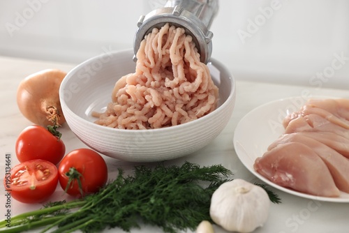 Canvastavla Manual meat grinder with chicken mince and ingredients on white marble table in
