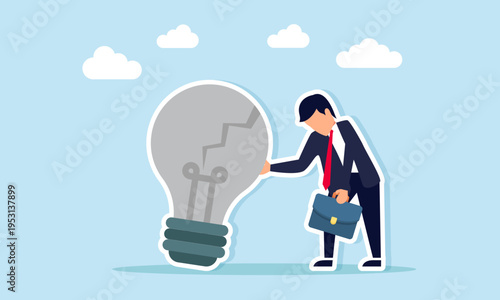 Sad businessman leaning on broken light bulb illustration of failure to implement business idea
