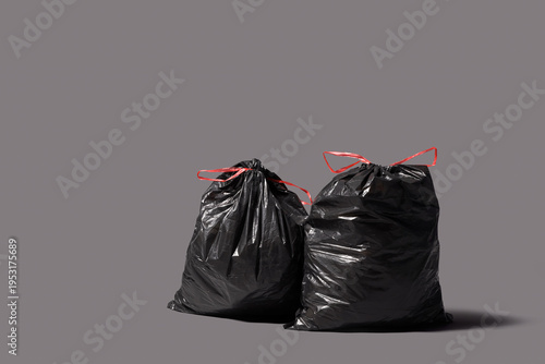 Full garbage bags on grey b...